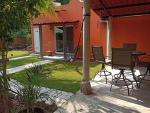a patio with chairs and a table in front of a house at Manzanillo BNB in Manzanillo