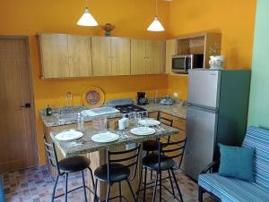a kitchen with a table with chairs and a refrigerator at Manzanillo BNB in Manzanillo
