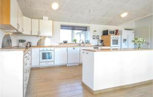 a kitchen with white cabinets and a counter top at Eight-Bedroom Holiday Home In Vestervig in Vestervig