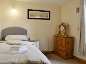 a bedroom with a bed and a mirror and a dresser at Doddick Chase Cottage - Uk1363 in Threlkeld +3 photos
