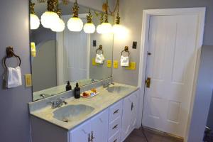 a bathroom with two sinks and a large mirror at The House Hotels - Acadia Farms in Northfield +89 photos