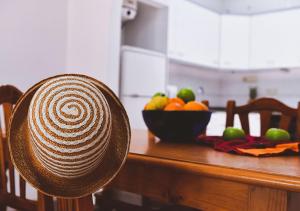 a hat sitting on a table with a bowl of fruit at Euromar II - TEPINSA Alquiler de Apartamentos in Torreblanca