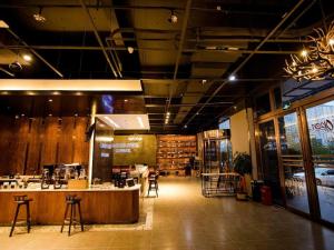 a restaurant with a bar in the middle of a room at James Joyce Coffetel Xinyang Municipal Government Railway Station in Xinyang