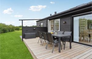 a deck with a table and chairs on a house at Nice Home In Frørup With Kitchen in Tårup