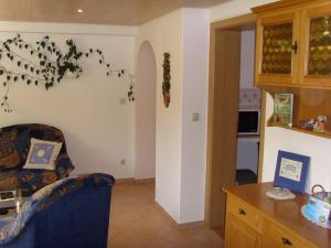 a living room with a chair and a kitchen at Ferienwohnung Adelheid in Eggenbach