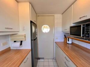 a kitchen with a refrigerator and a microwave at Modern San Alfonso del Mar - BBQ Parking Pool Wifi in Algarrobo