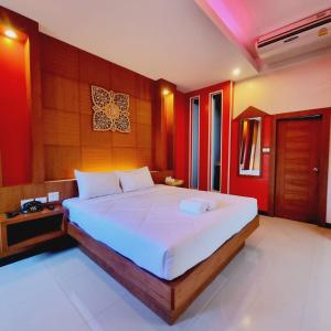 a bedroom with a large white bed with red walls at Hi End Hotel Sriracha in Ban Fang Daeng +24 photos