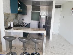 a kitchen with a counter and two stools in it at Espectacular apartamento excelente ubicación in Ricaurte