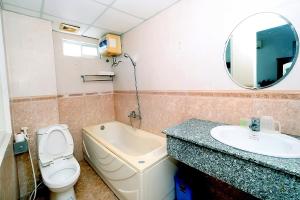 a bathroom with a sink and a toilet and a mirror at Blue Sea 01 Hotel in Nha Trang