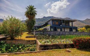 a house with a garden in front of it at Avartarn Miracles Hotel in Ban Soi Rakhlong