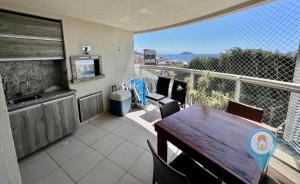 Un balcón con mesa y vista al mar. en N1401 VISTAMAR Amplo Club Praia Beto Carrero 4qrts, en Penha