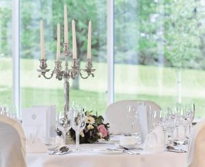 a table with a white table with candles and wine glasses at Macdonald Drumossie Hotel Inverness in Inverness