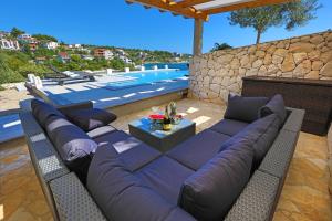 a couch sitting on a patio next to a pool at Villa Hera Sevid in Sevid