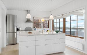 a kitchen with white cabinets and a large window at Holiday Home Tornehagen Holbæk Ii in Holbæk