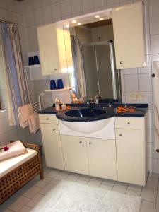 ein Bad mit einem Waschbecken und einem Spiegel in der Unterkunft Haus Anneliese in Mühlbach am Hochkönig