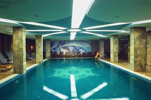 a woman sitting in a swimming pool in a hotel at Winslow Infinity Aparthotel in Bansko