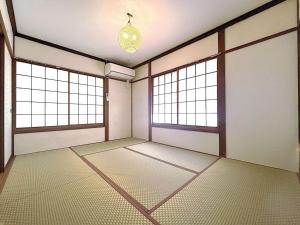 an empty room with two windows and a chandelier at リゾートハウス正波2 in Azumino +13 photos