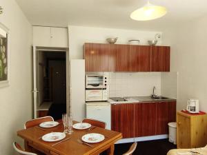 Les AdretsStudio cabine skis aux pieds, balcon, centre station - FR-1-771-65的带桌椅的厨房和带吧台的厨房