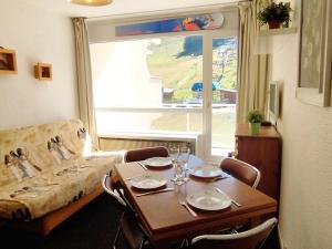 Les AdretsStudio cabine skis aux pieds, balcon, centre station - FR-1-771-65的客厅里有一张桌子和一张沙发