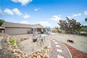 a house with a yard with chairs and a patio at 4 BR Home with Game Room! Family Friendly! Centrally Located! in San Diego