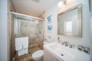 a bathroom with a sink and a toilet and a mirror at 4 BR Home with Game Room! Family Friendly! Centrally Located! in San Diego +54 photos