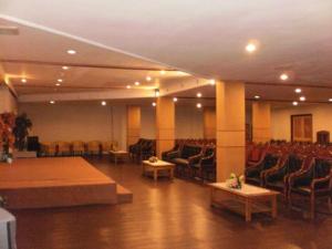 Una gran sala con sillas, una mesa y un escenario. en Bintang Hotel, en Klandasan-besar
