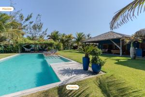 a swimming pool in front of a house at Villa Boungavilea Fortim Casa Frente Mar de Luxo in Fortim