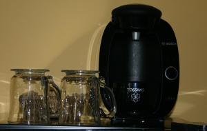a coffee maker and two glass jars on a counter at Motel des Pentes et Suites in Saint-Sauveur-des-Monts