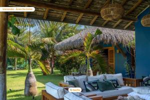 a living room with a couch and two palm trees at Villa Boungavilea Fortim Casa Frente Mar de Luxo in Fortim