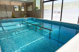 duży basen z niebieskimi płytkami na podłodze w obiekcie Hotel-Clinic Dr. Gechevi w mieście Paweł Banja