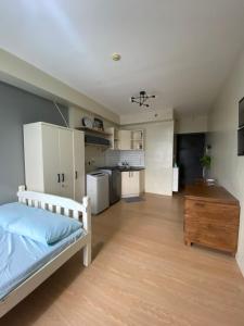 a large room with a bed and a kitchen at Condo near ATC- Molito Alabang, Muntinlupa in Manila