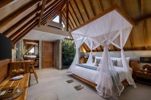 a bedroom with a bed with a mosquito net at Lasamana Villas Ubud by GenuineHost in Ubud +40 photos