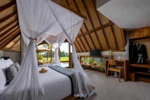 a bedroom with a bed with mosquito net at Lasamana Villas Ubud by GenuineHost in Ubud