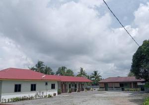 a building with a red roof and two buildings at D'Desa Qaseh Chalet in Kampong Pantai Ayer Hitam