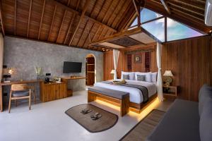 a bedroom with a bed and a desk and a television at Lasamana Villas Ubud by GenuineHost in Ubud
