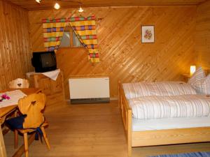 a bedroom with a bed and a desk and a television at Haus Anneliese in Mühlbach am Hochkönig