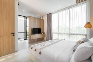 ein Schlafzimmer mit einem großen Bett und einem Fernseher in der Unterkunft Private Villa Ayra 9A 10mins to Melasti Beach in Uluwatu + 24 Fotos