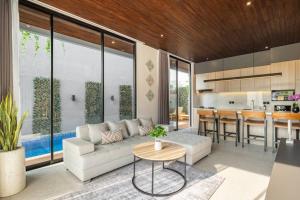 ein Wohnzimmer mit einer weißen Couch und einer Küche in der Unterkunft Private Villa Ayra 9A 10mins to Melasti Beach in Uluwatu