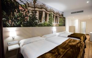 
a hotel room with a large bed and a painting on the wall at Hotel BESTPRICE Gracia in Barcelona
