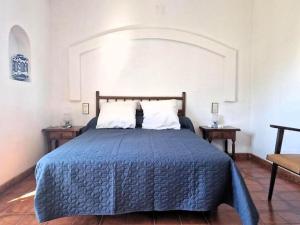 ein Schlafzimmer mit einem Bett mit einer blauen Bettdecke in der Unterkunft Casa Rubens – Vistas al mar | Playa a 7 min | Parking - ES-258-104 in Roses