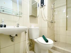 a bathroom with a toilet and a sink at Homey and Nice 3BR at Springlake Summarecon Bekasi Apartment By Travelio in Bekasi