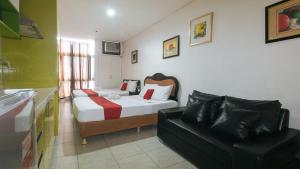a bedroom with a bed and a couch in a room at RedDoorz at TJMG by Bel Air Polaris Makati in Manila +43 photos