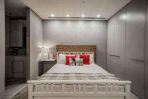 金斯顿Modern studio with free wifi and parking的卧室里有一张白色的大床，上面有红色的枕头