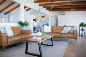 a living room with two couches and a coffee table at Nautilus On The Hill - Airlie Beach in Airlie Beach