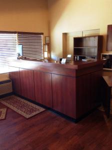 um escritório com uma grande secretária de madeira e uma bancada em Grays Harbor Inn & Suites em Aberdeen