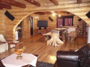 un soggiorno con divano e TV in una cabina di Cabana Vultur a Vatra Dornei