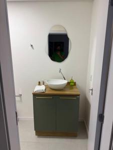 Un baño con un lavabo y un espejo. en Lindo e novo apartamento, en Santana do Livramento