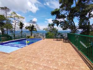 a patio with a swimming pool and a table at Finca Hotel Villa Ilusión in Pereira