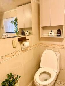 a small bathroom with a toilet and a window at Cozyhouse in Busan