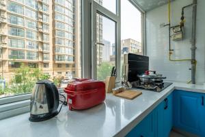 a kitchen with a appliance on a counter with a window at Zhengzhou Huiji·Province Sport Centre· Locals Apartment 00161400 in Zhengzhou
